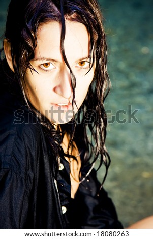 Sensual young woman with her hair wet staring at camera.