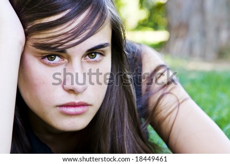 Young staring woman laying on the grass