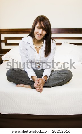 Long haired businesswoman posing in bed.