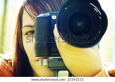 Young woman eye behind slr camera.