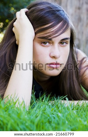 Young staring woman laying on the grass