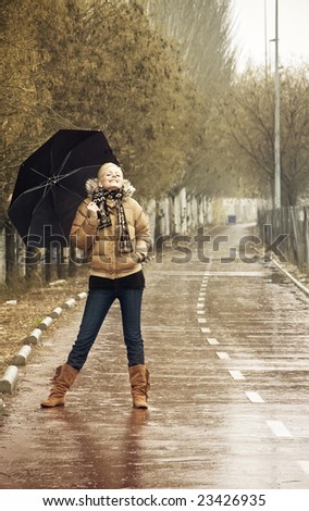 Happy young blond woman in a rainy day.