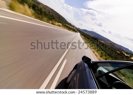 Cruising the countryside in a blue car at high speed.
