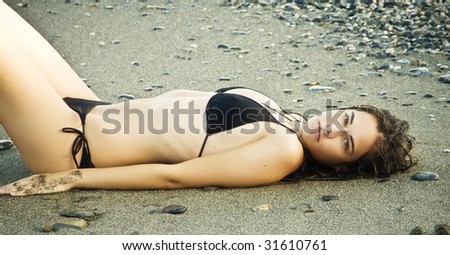 Laying beauty wearing black small bikini.