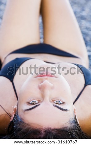 Laying beauty wearing black small bikini.