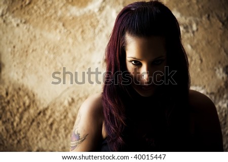 Young beautiful redhead woman portrait on cracked wall.