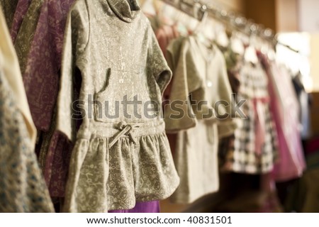 Clothes for little girls in a fashion shop. Shallow focus.