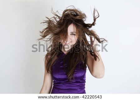 Young beautiful girl with windy hair over white background.