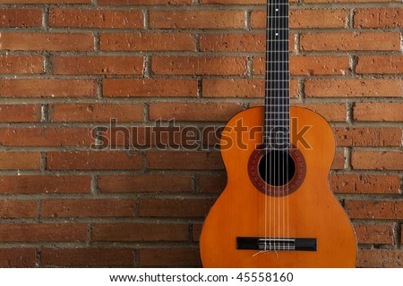 Spanish guitar against red brickwall