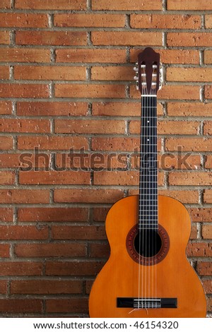 Spanish guitar against red brickwall