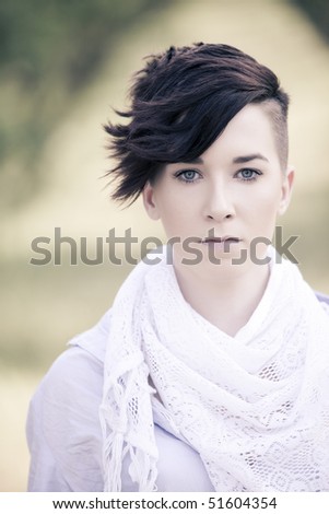 Young girl with modern haircut staring at camera.