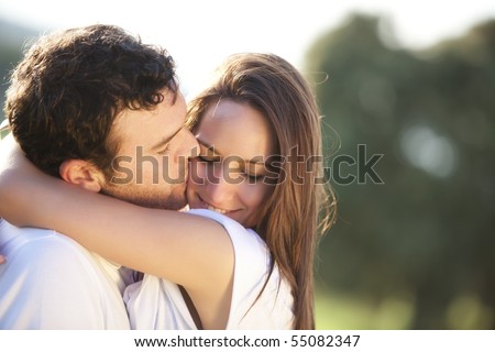 Young beautiful couple in a sweet cheek kiss