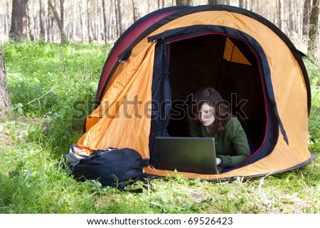 Young woman using laptop in the middle of the forest