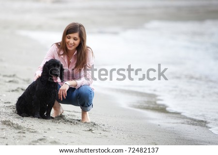Young beautiful girl with her dog in the beach