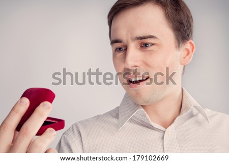 man holding an open jewelry box and opened his mouth (retro)