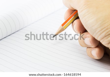Hand with pencil on notebook