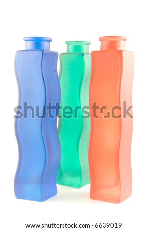 Three wavy glass vases of red, green and dark blue colors on a white background