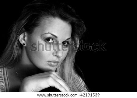 Portrait of the smiling attractive young girl  the blonde on black background. Black and White image.