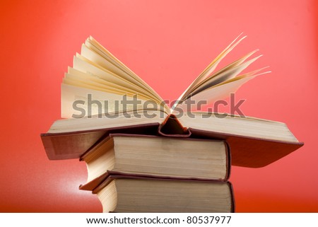 Old books with red cover on a red background