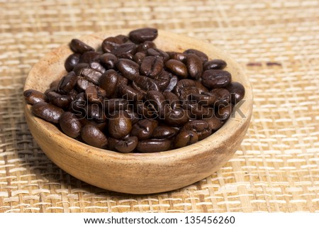 Fresh roasted coffee beans on light textured surface