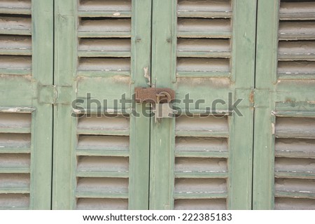 Old wooden door with peeling paint under the influence of weather.
