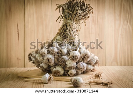 sliced garlic, garlic clove, garlic bulb in wicker basket place on chopping block on vintage wooden background