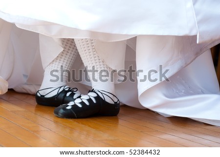 Feet in ghillies surrounded by wedding dress