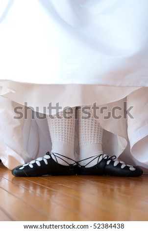 Feet in ghillies surrounded by wedding dress