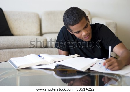 Sixteen year old boy working on his homework.
