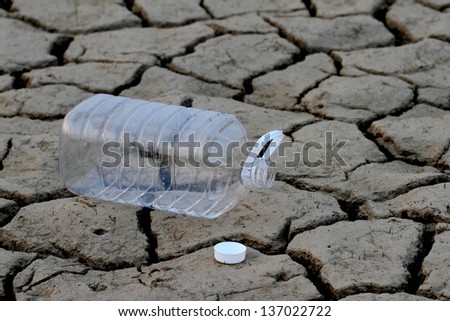 empty water bottle on Drought cracked earth
