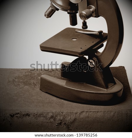 Old microscope on old book