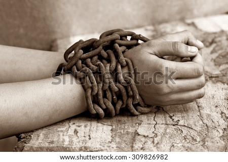 woman hands tied up with chain , Human rights violations concept