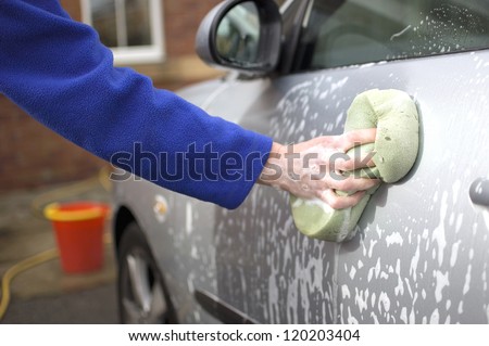 Woman washing car outside her home