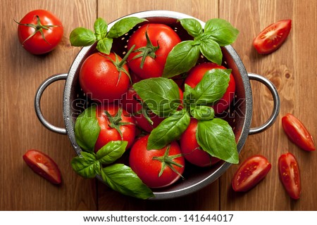 Tomatoes With Basil In Colander On Wooden Table Background. Food Composition. Top View