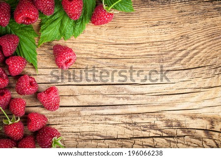 Raspberries on wooden table background
