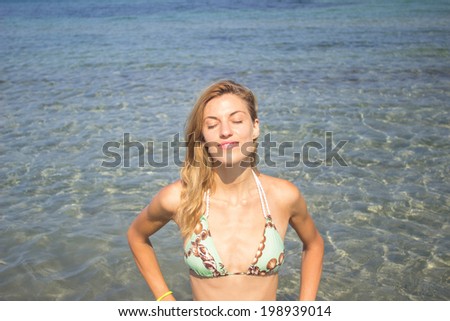 Beautiful woman sunbathing in the sea water, portrait