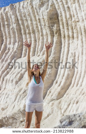 Woman tossing up sea salt at salt marsh
