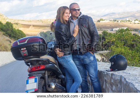 Happy couple traveling by motorbike