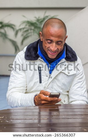 Smiling man with mobile phone sitting at table