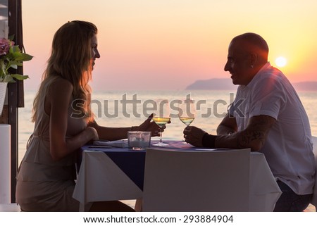 Young adult couple on vacation drinking wine in restaurant