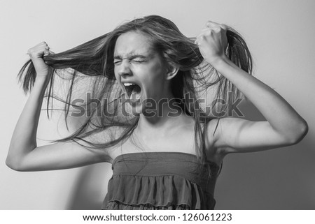 portrait crying women with long hair on gray background