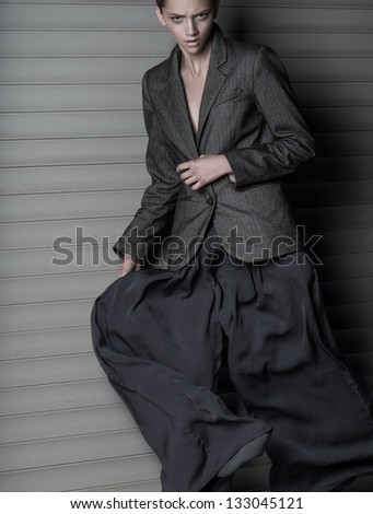 Fashion women jump in suit on gray background
