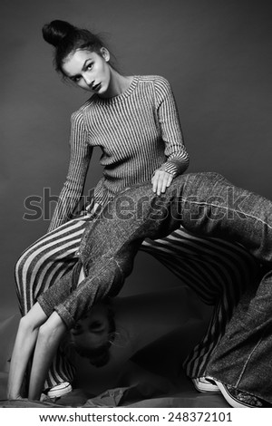 fashion portrait of two pretty model dance in studio on grey background