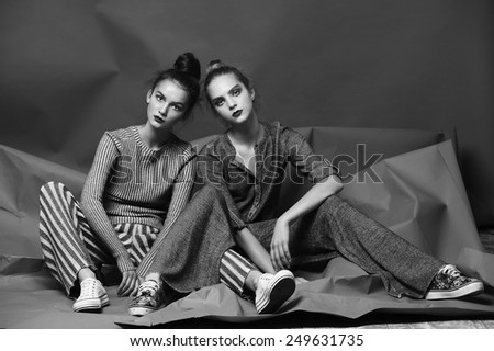 two fashion model girl posing on gray background