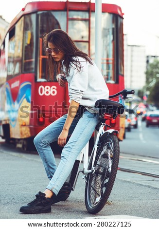 beautiful young hipster woman with bike in the city. Urban fashion lifestyle