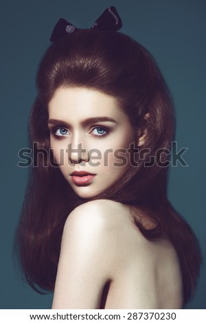 Glamour portrait of beautiful woman model with fresh daily makeup and funny wavy hairstyle. Fashion shiny highlighter on skin, sexy gloss lips make-up and natural eyebrows.dark background