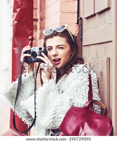 Hipster female photographer with not professional camera, natural light, street fashion style