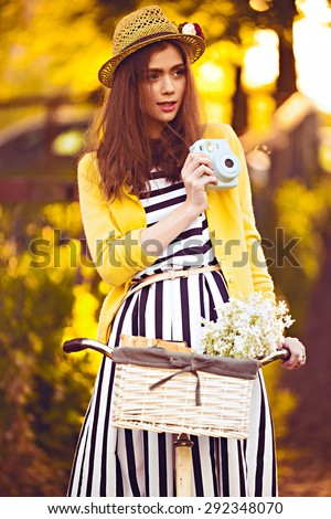 hipster photographer beautiful, elegantly dressed woman with bicycle. Beauty, fashion and lifestyle