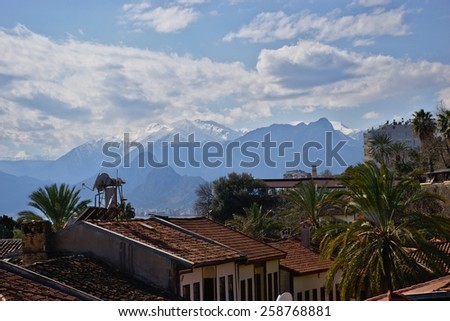 Roofs of the old city of Antalya in front of mountains with snow peaks