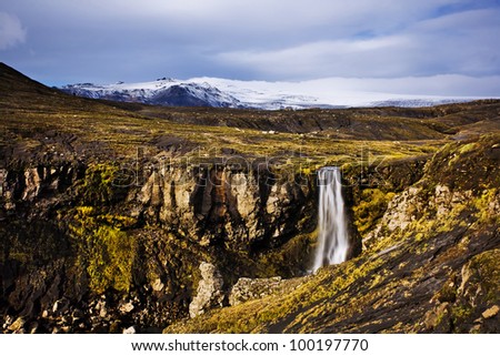 Iceland landscape, waterfall and famous Eyjafjallajokull volcano in background